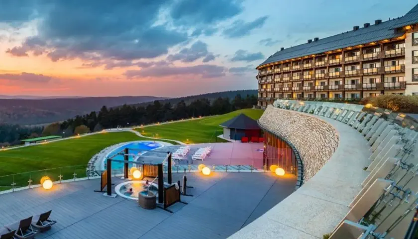 Luksusowy hotel z basenem i jacuzzi na tarasie, otoczony malowniczymi wzgórzami. To jeden z najlepszych hoteli w Polsce, idealny na relaks.