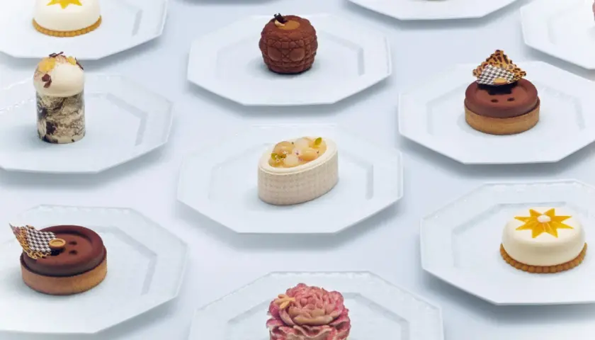 Collection de petits gâteaux raffinés, un véritable produit de luxe alimentaire, présentés sur des assiettes blanches.