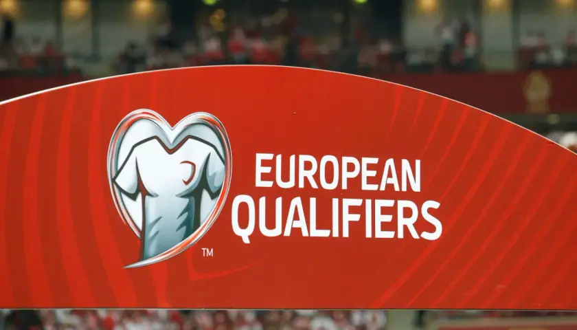Czerwony baner z napisem "EUROPEAN QUALIFIERS" i symbolem koszulki w sercu. To część rozgrywek eliminacyjnych do Mistrzostw Europy.