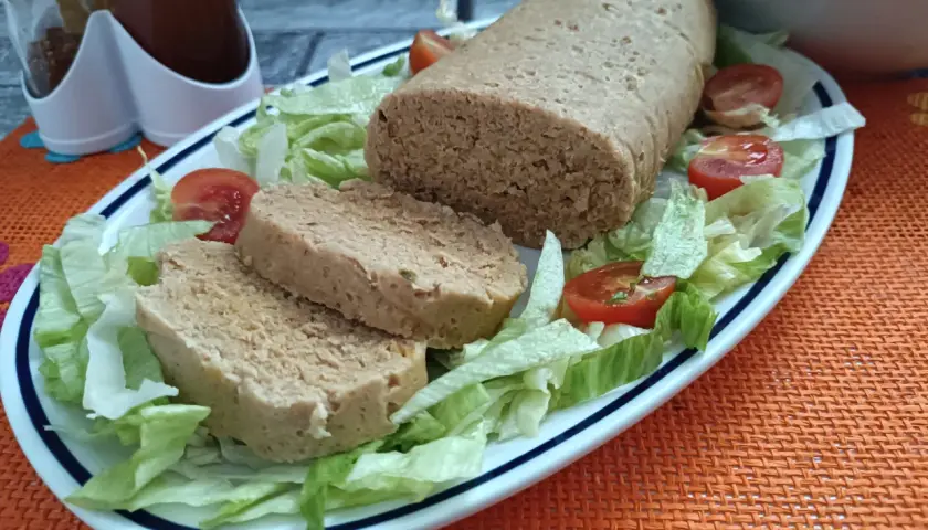 Un gustoso polpettone di tonno, affettato e servito su un letto di lattuga fresca con pomodorini.