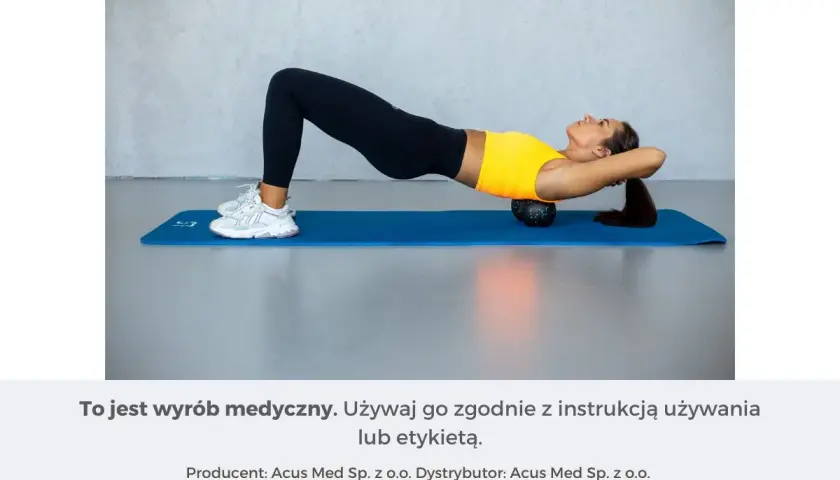 Kobieta wykonuje ćwiczenia na wdowi garb, leżąc na macie z wałkiem pod plecami.