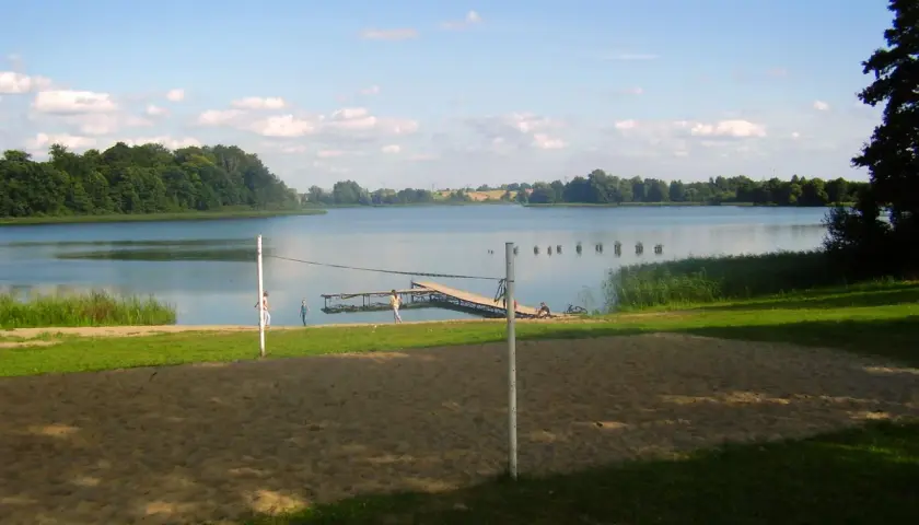 Piękny dzień nad jeziorem Skiertąg. Plaża, molo i zielone drzewa tworzą idylliczny krajobraz.