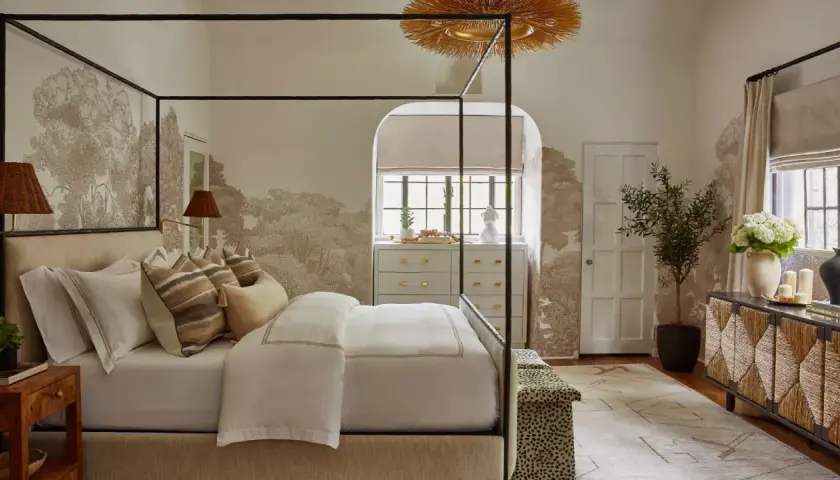 A serene bedroom featuring a canopy bed, botanical wallpaper, and a mix of natural textures, showcasing diverse bedroom styles.