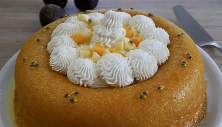 Un baba au rhum doré, garni de crème fouettée, fruits exotiques et graines de fruits de la passion. Un délice !