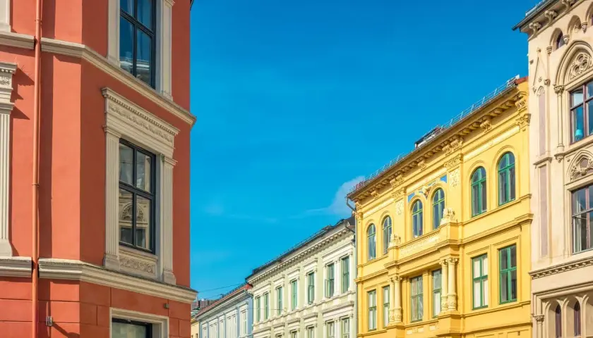 Kolorowe kamienice w Oslo, idealne na spacer przed rejsem promem do Oslo. Jasne słońce i błękitne niebo.