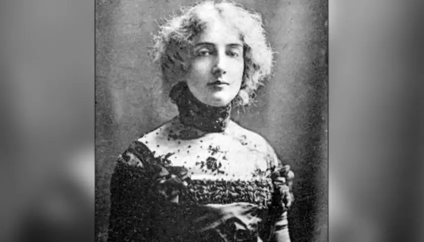 Portret Dagny Juel Przybyszewskiej, artystki o burzy blond włosów, w ozdobnej sukni z koronkowym kołnierzem.