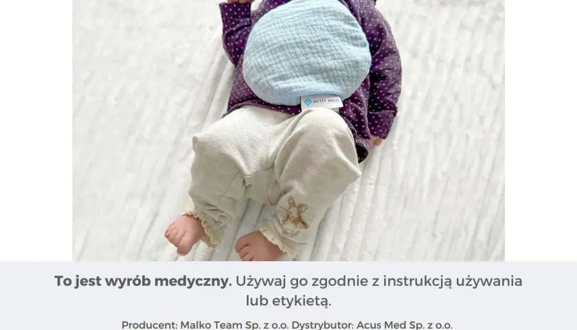 Niemowlę z termoforem z pestek wiśni na brzuszku. Dowiedz się, jak używać termofor z pestek wiśni, by przynieść ulgę maluszkowi.