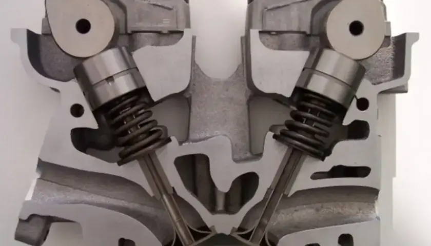 Przekrój głowicy silnika z widocznymi zaworami i sprężynami. Widać mechanizm działania cylindrów w silniku.