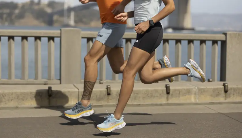 Dwie osoby biegną po moście w butach Hoka, gotowe na wyzwanie kingrunner ultra.