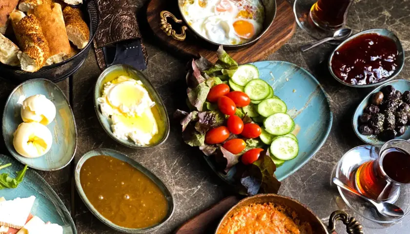 Pyszne śniadanie w jednej z najlepszych restauracji Warszawa: jajka sadzone, sery, pieczywo, oliwki, dżem i herbata.