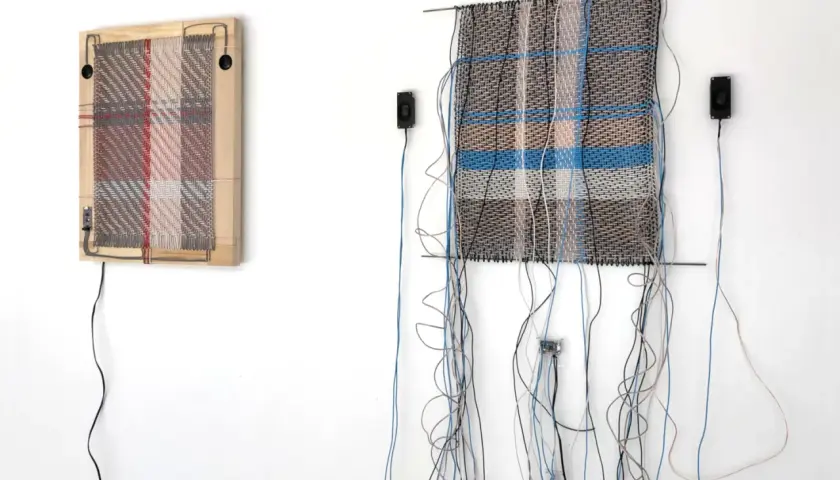 Deux œuvres d'art de tissage dessin, ornées de fils et de câbles, sont accrochées à un mur blanc.