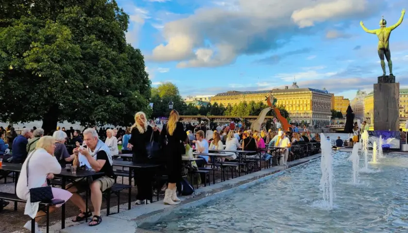 Folk njuter av sommarkvällen vid fontänen, en del av programmet för kulturfestivalen.