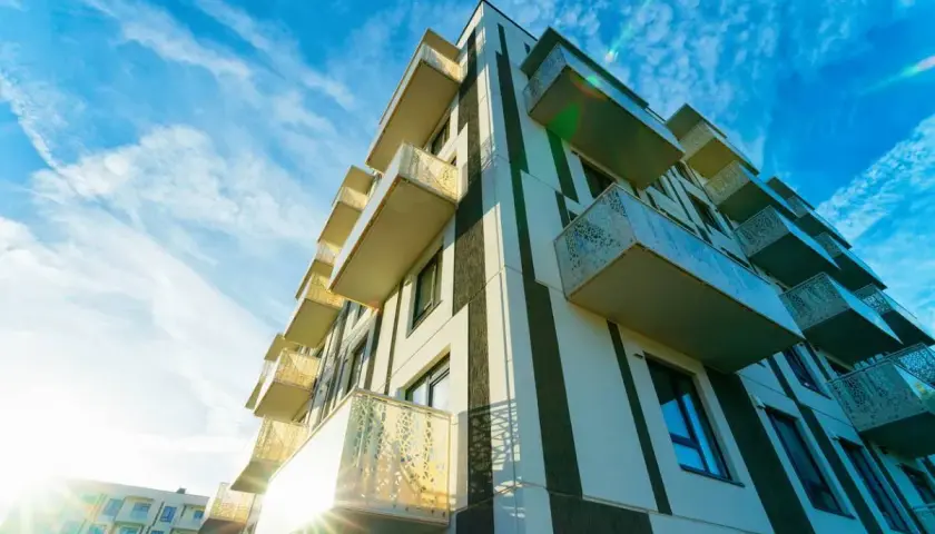 Immeuble moderne aux balcons saillants, sous un ciel bleu zébré de nuages. Un projet qui pourrait faire l'objet d'un recours pour perte d'ensoleillement.