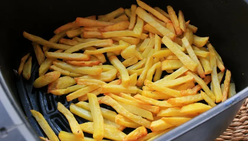 Patatas fritas doradas y crujientes recién hechas en freidora de aire. ¡Listas para disfrutar!