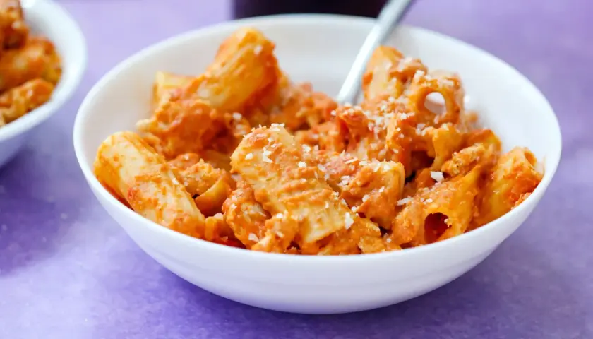 Un piatto di pasta al dente con sugo rosso e parmigiano, un classico dei piatti tipici napoletani.