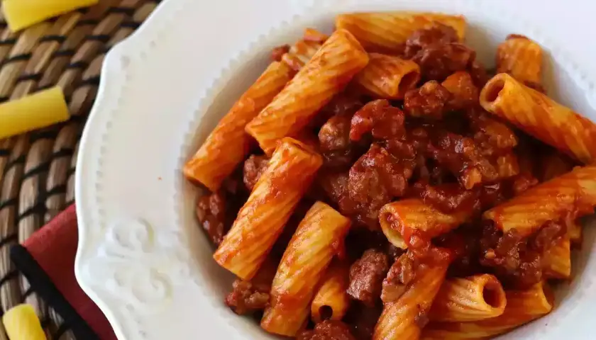 En tallrik med rigatoni pasta och en smakrik köttfärssås. Enkel och god salchicha pasta.