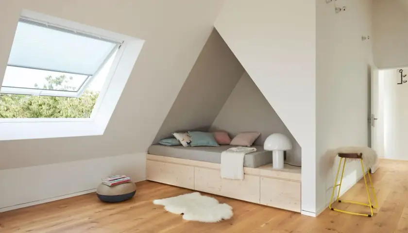 Coole jugendzimmer jungen einrichtungsideen: Dachgeschoss-Nische mit Bett, Stauraum und Dachfenster. Gemütliche Kissen und Schaffell laden zum Entspannen ein.