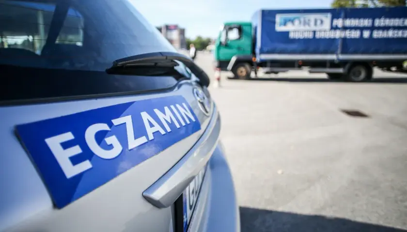 Samochód z napisem "EGZAMIN" na tylnej klapie. Czy głuchoniemy może mieć prawo jazdy? Tak, po zdaniu egzaminu.