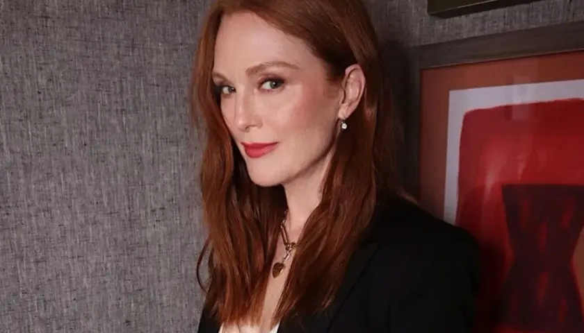 Eleganckie stylizacje do rudych włosów: Julianne Moore w czarnej marynarce i z subtelną biżuterią.