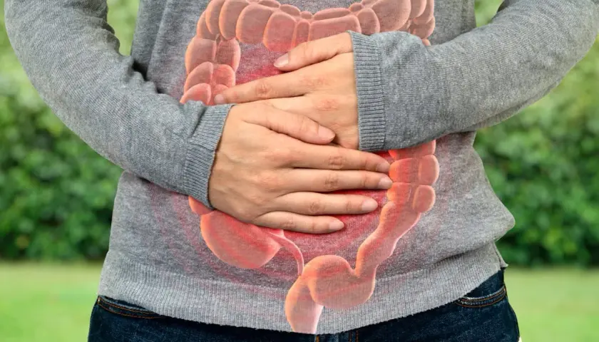 Personne tenant son ventre, avec une image superposée d'intestins rouges. Selles liquides comme de l'eau que faire ?
