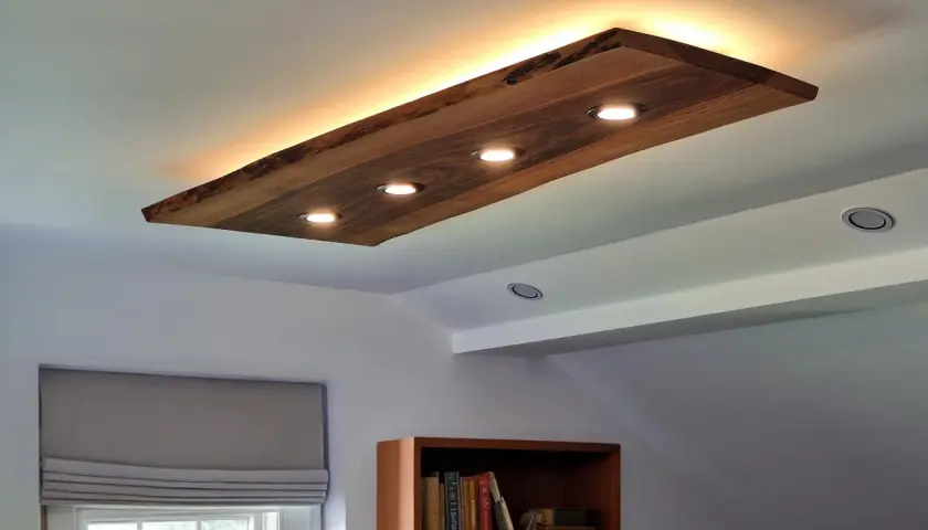 Un elegante plafón led madera ilumina la estancia, con focos integrados y luz indirecta que crea un ambiente cálido.
