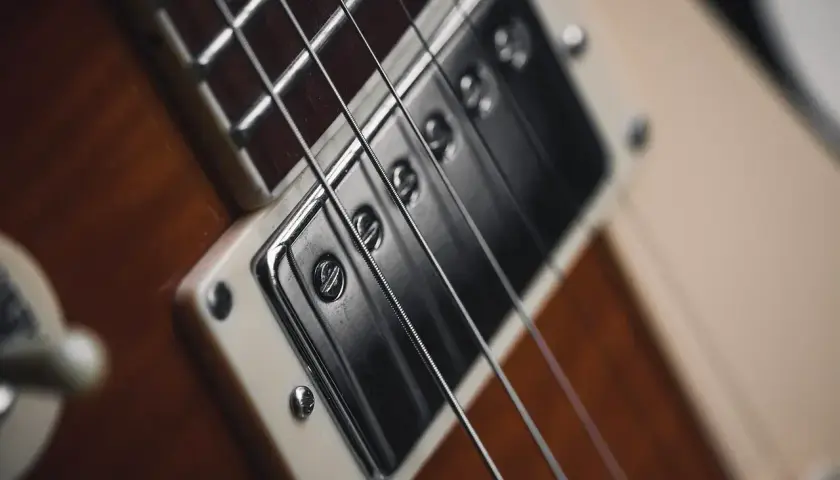 Zbliżenie na przetwornik i struny gitary elektrycznej, idealne do tworzenia eterycznego shoegaze.