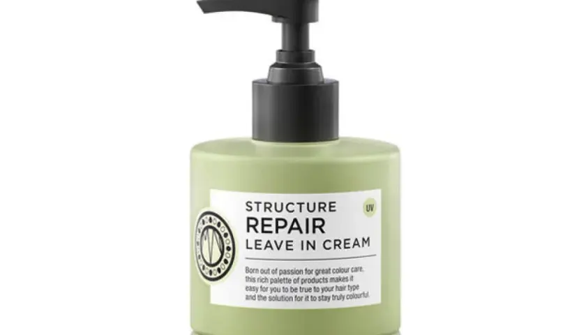 En ljusgrön flaska med pumpdispenser, märkning "Structure Repair Leave In Cream" för torrt hår.