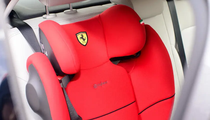 Czerwony fotelik samochodowy Cybex z logo Ferrari, gotowy do montażu. Instrukcja jak zamontować fotelik w samochodzie.
