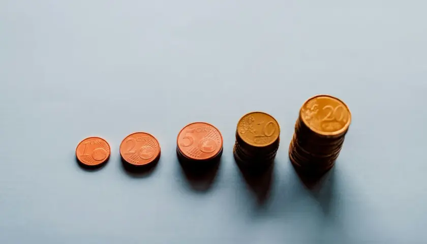 Rosnące stosy monet euro od 1 do 20 centów symbolizują waloryzację i rewaloryzację wartości pieniądza.