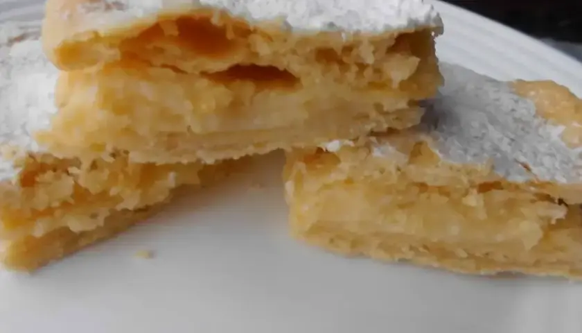 Kruche ciasto przełożone kremem, posypane cukrem pudrem. To smak dzieciństwa, czyli napoleonka przepis babci.