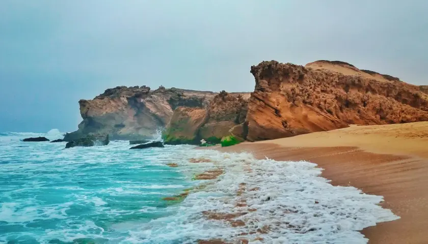 Felsige Küste mit türkisfarbenem Meer und Wellen. Ein perfekter marokko urlaub am meer.