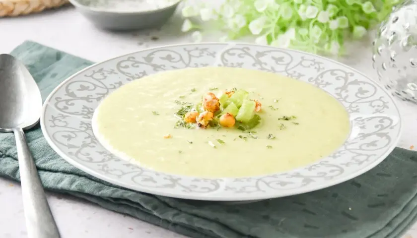 Crema de apio suave y reconfortante, decorada con trocitos de apio fresco y garbanzos crujientes.