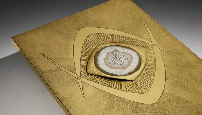 Plaque en laiton brossé avec une agate polie incrustée, ornée de motifs géométriques stylisés.