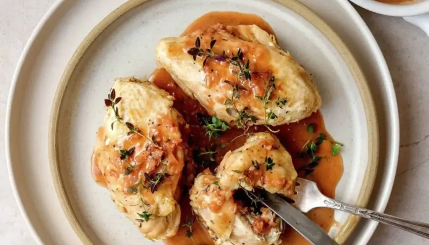 Trois morceaux de poulet généreusement nappés d'une sauce onctueuse, garnie de thym frais. Un plat qui évoque la richesse de la gastronomie lyonnaise.