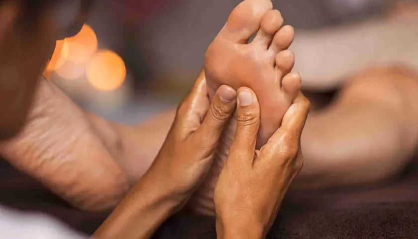 Mani esperte eseguono un rilassante foot massage, sciogliendo tensioni e donando benessere.