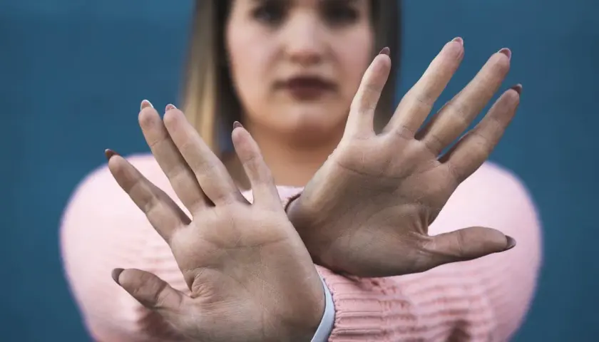 Kobieta z dłońmi przed twarzą, gestem mówiącym "stop" – to jest właśnie sprzeciw wobec shaming.