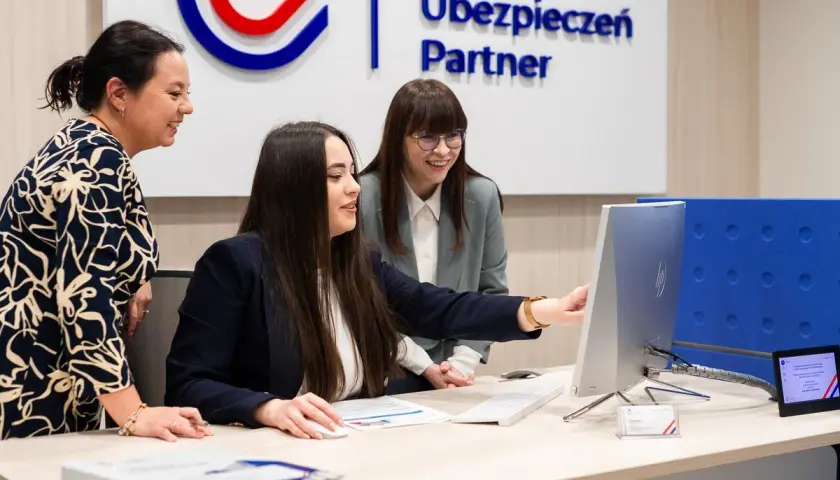 Trzy kobiety w biurze patrzą na ekran komputera.