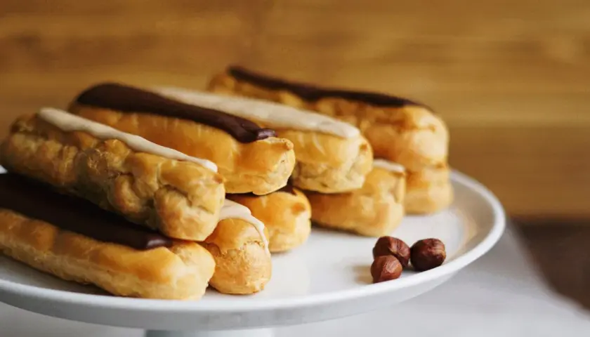 Una pila di éclair con glassa al cioccolato e vaniglia, pronti per essere gustati. La ricetta perfetta per un dolce momento.