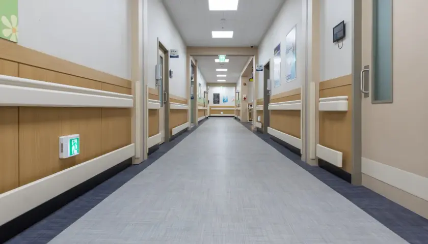 Długi, pusty korytarz szpitalny, który może budzić skojarzenia z dożywotni pobyt w szpitalu psychiatrycznym.