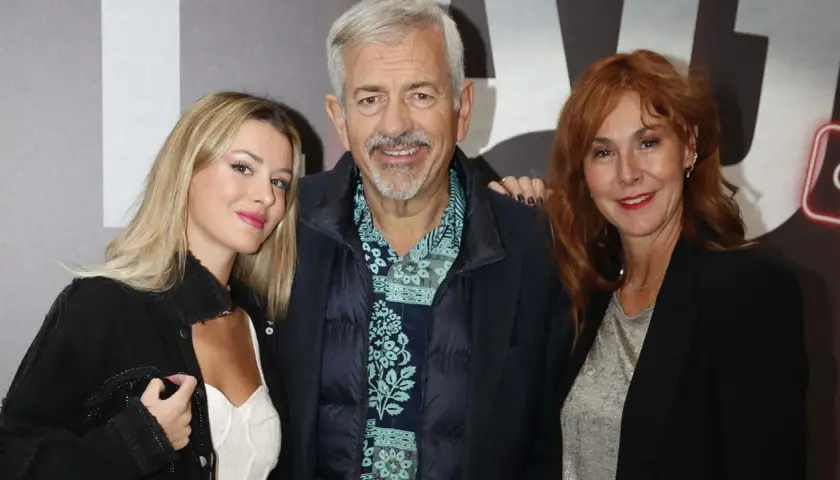 Carlos Sobera posa con sus hijos, una joven rubia y una mujer pelirroja, sonriendo a la cámara.