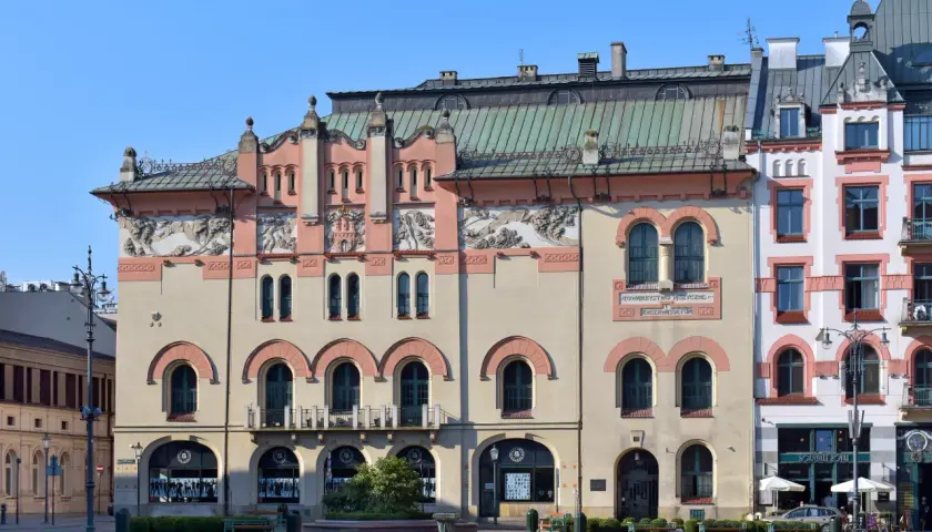 Elegancka fasada Teatru Starego w Krakowie z ozdobnymi detalami i łukowymi oknami.