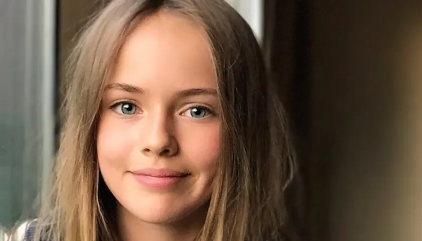 Uśmiechnięta dziewczyna o niebieskich oczach i blond włosach, która wygląda jak najładniejsza dziewczyna na świecie.