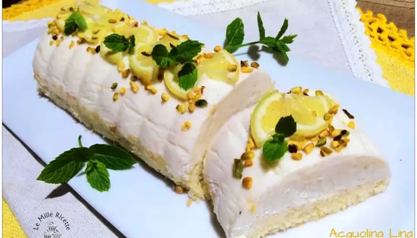 Delizia al limone: rotolo soffice con crema al limone, guarnito con fettine di limone, pistacchi e menta.