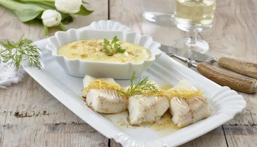 Elegancki halibut przepis: delikatne kawałki ryby z cytrynową skórką i koperkiem, podane z kremowym sosem. Idealne danie.