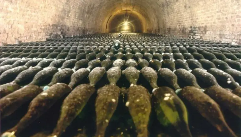 Des milliers de bouteilles de champagne vieillissent dans les caves voûtées de la visite cave Deutz.