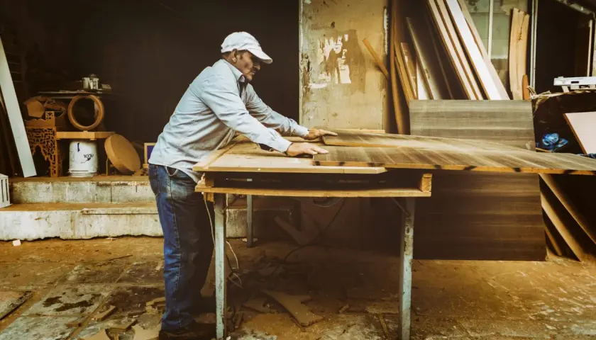 Artisan ajustant des planches de bois. Si votre cuisine est mal posée, quel recours ?