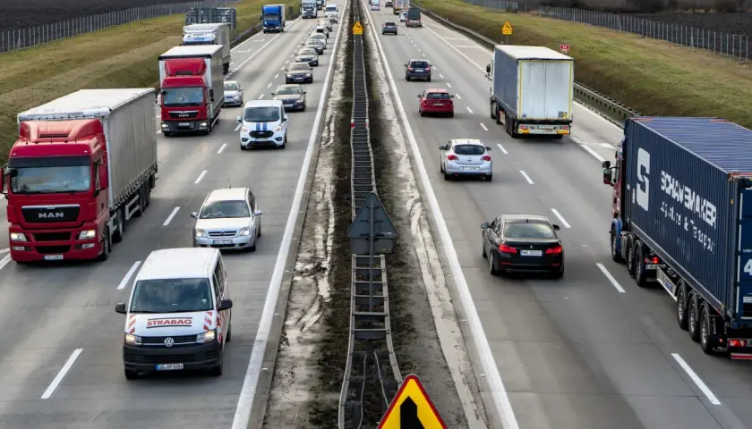 Ruch na autostradzie, gdzie wiele samochodów i ciężarówek jedzie w kierunku Wrocławia. Czy autostrada na Wrocław jest płatna?