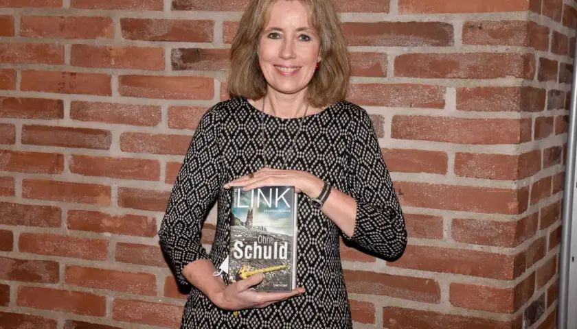 Eine Frau hält das Buch "Ohne Schuld" aus der kate-linville-reihe.