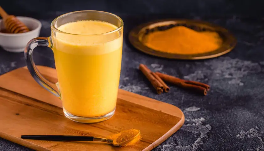 Goldene Kurkuma Milch mit Zimt und Honig. Die Kurkuma Milch Wirkung ist bekannt für ihre entzündungshemmenden Eigenschaften.