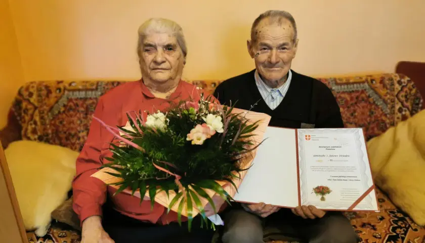 Para Genowefa i Jan Dziedzic świętuje 70 rocznicę ślubu. Otrzymują gratulacje i bukiet kwiatów.